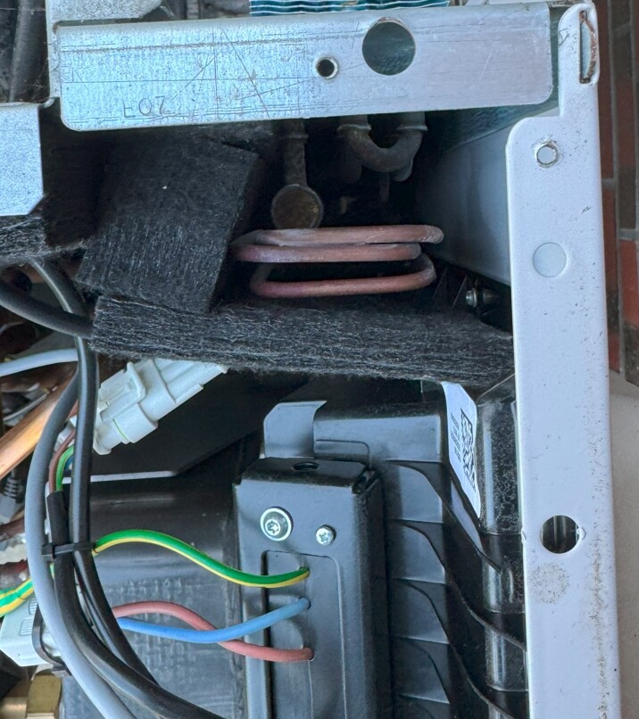 Innenansicht eines elektrischen Geräts: Kabel, Erdung, Kupferwicklung, Metallrahmen.