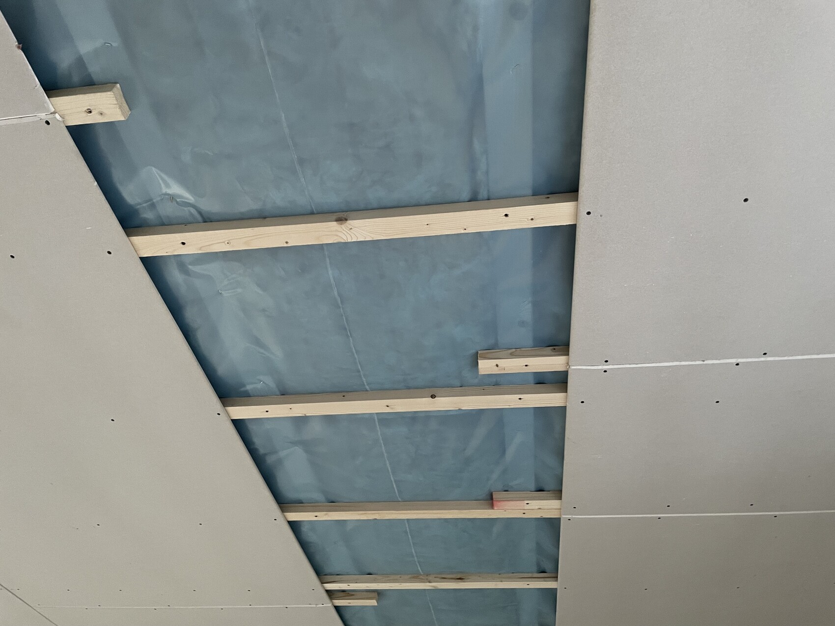 Deckenunterbau mit Holzlatten, blauer Feuchtigkeitsschutzfolie und Gipskartonplatten