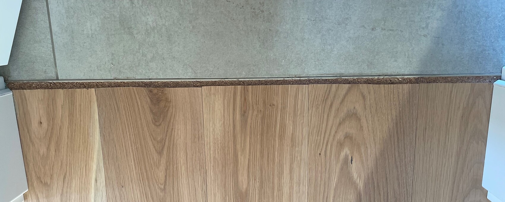 Nahaufnahme von Holzfronten eines Kuechenschranks mit grauer Steinplatte