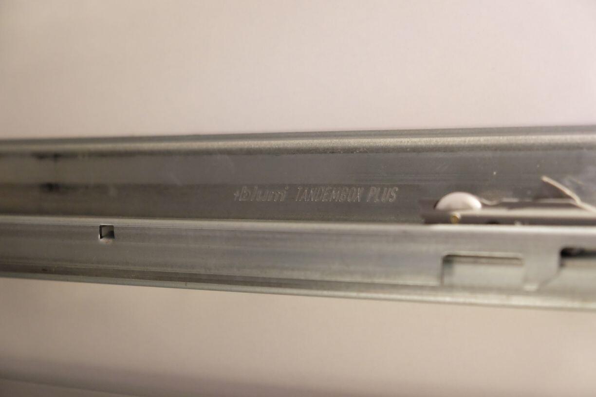 Nahaufnahme einer metallischen Schubladenschiene mit Beschriftung Blum Tandem Plus