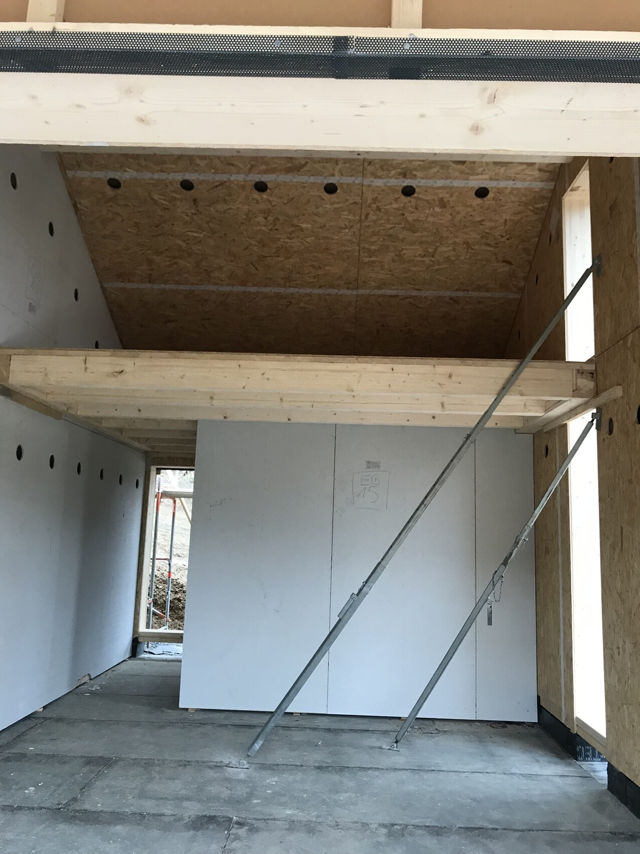 Innenraum eines Bauprojekts mit Trockenbauwänden, OSB-Decke und Stützstreben