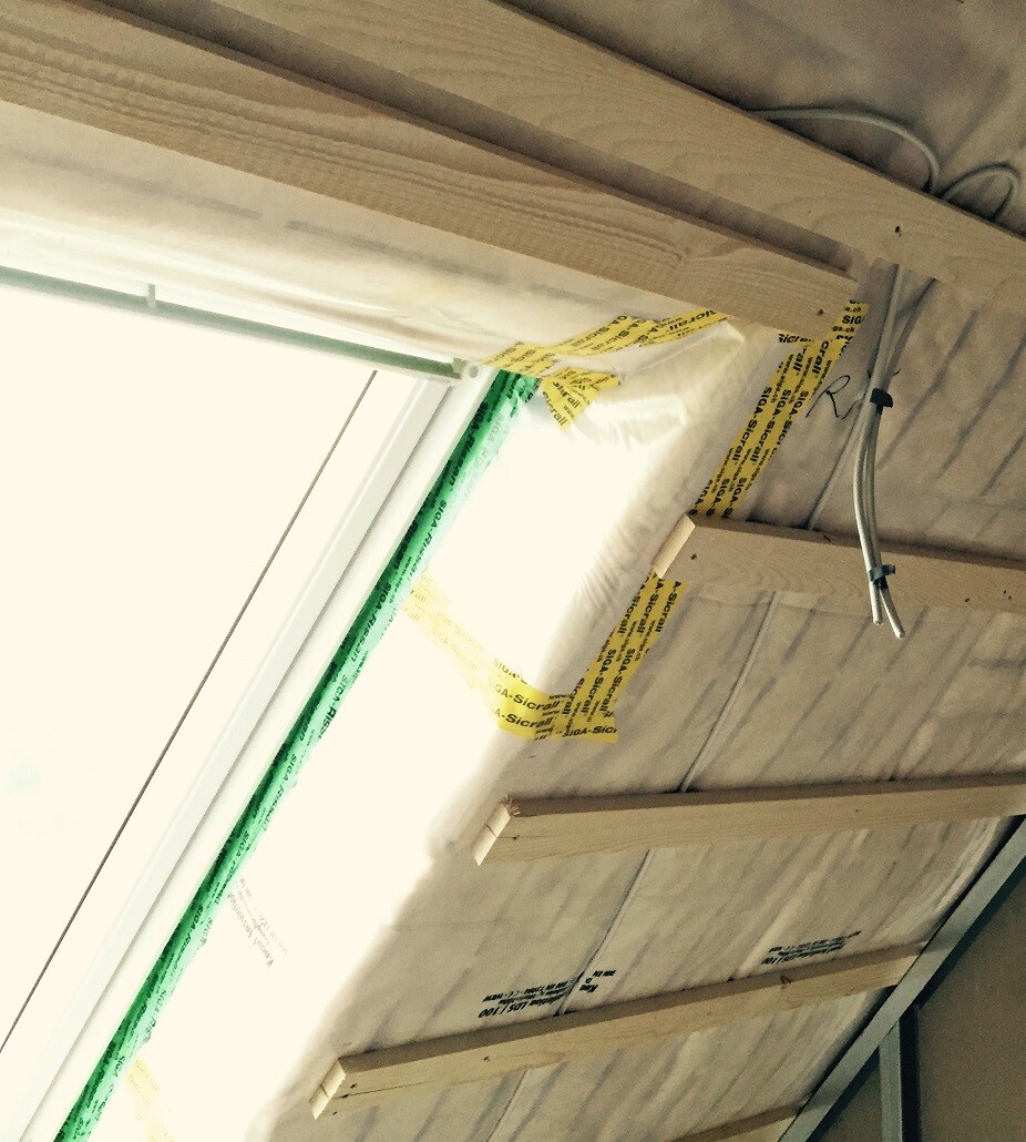 Baustelle Innenausbau: Dämmung, Holzlatten und Kabel an der Decke neben Fenster