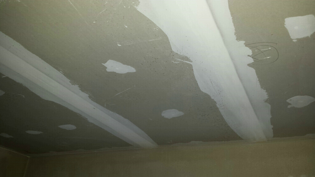 Rohdecke mit Spachtelarbeiten und sichtbaren Kabeln im Innenausbau