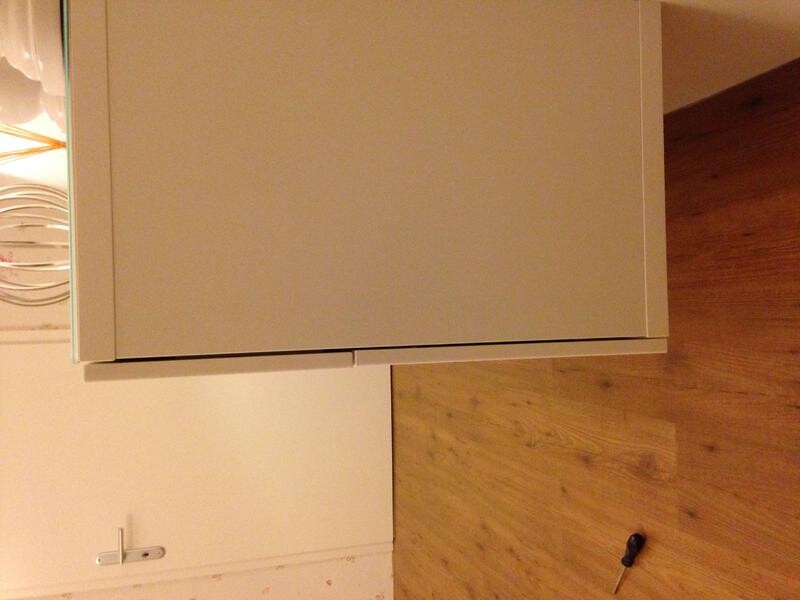 Weißer Einbauschrank im Innenausbau auf Holzboden, Werkzeug liegt daneben.