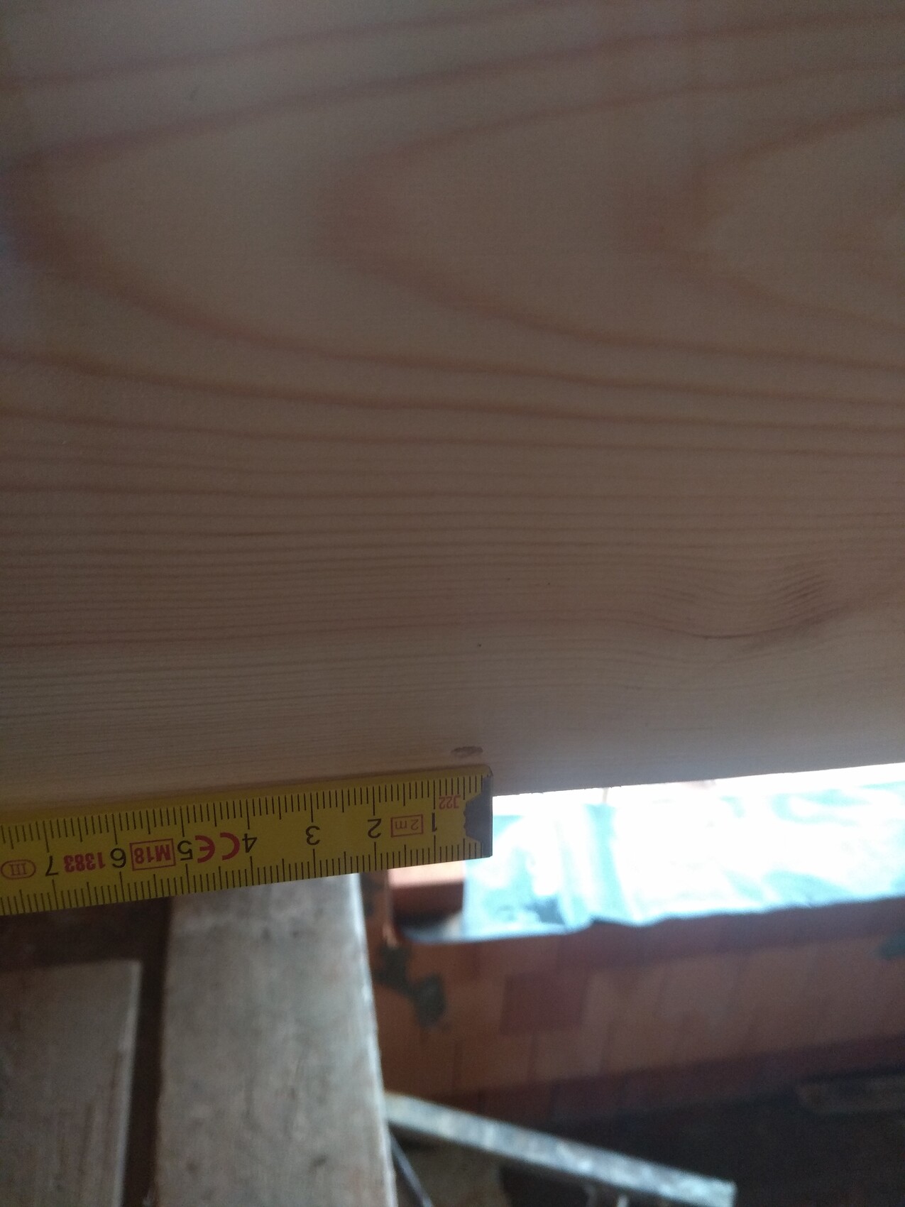 Nahaufnahme einer Holzwandplatte mit Maßband beim Innenausbau.