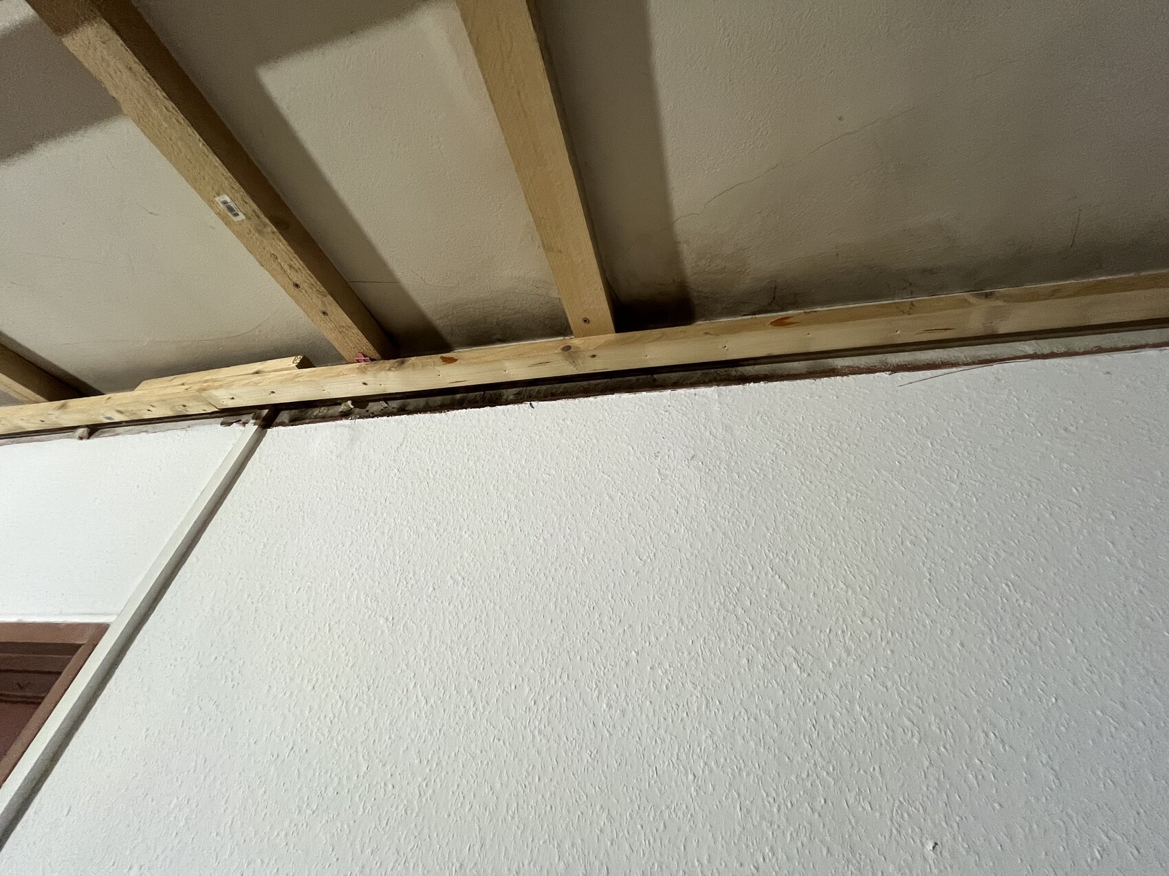 Innenbereich mit sichtbaren Holzbalken und offener Decke in Bauphase