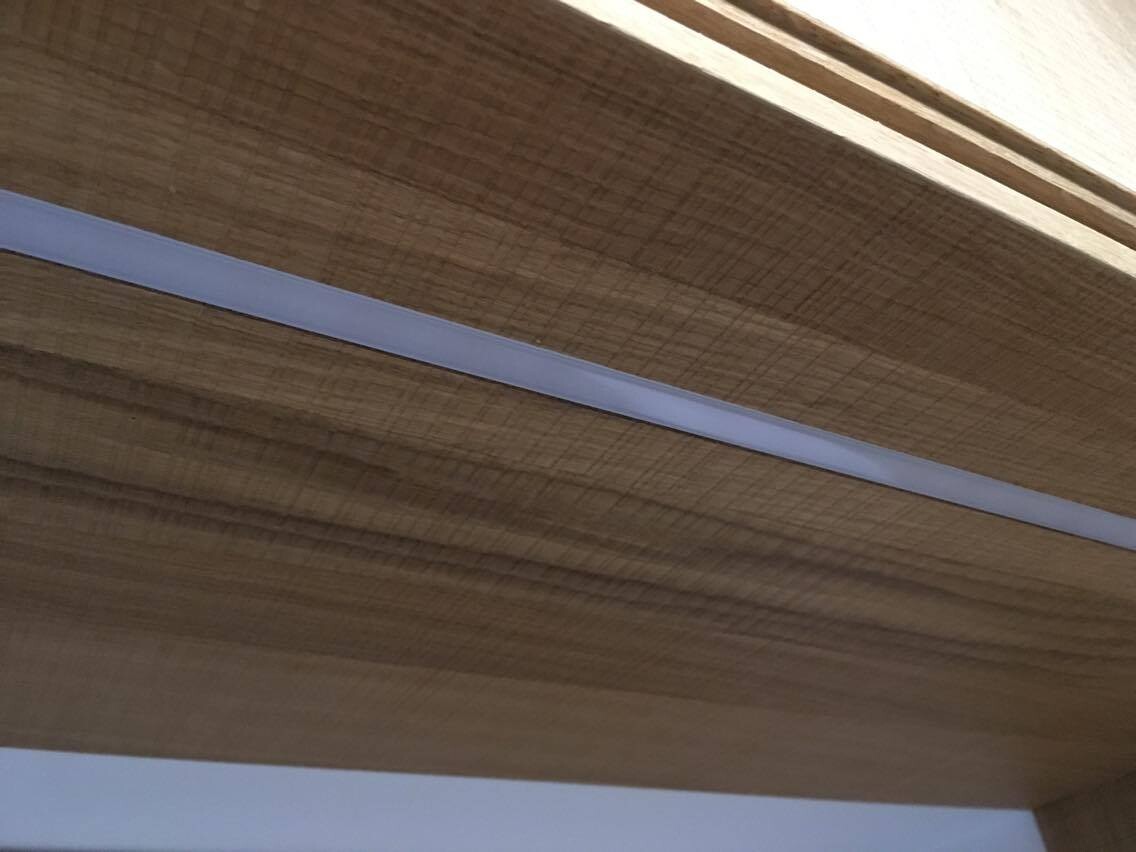 Nahaufnahme einer Holzverkleidung mit heller Leiste an der Kante