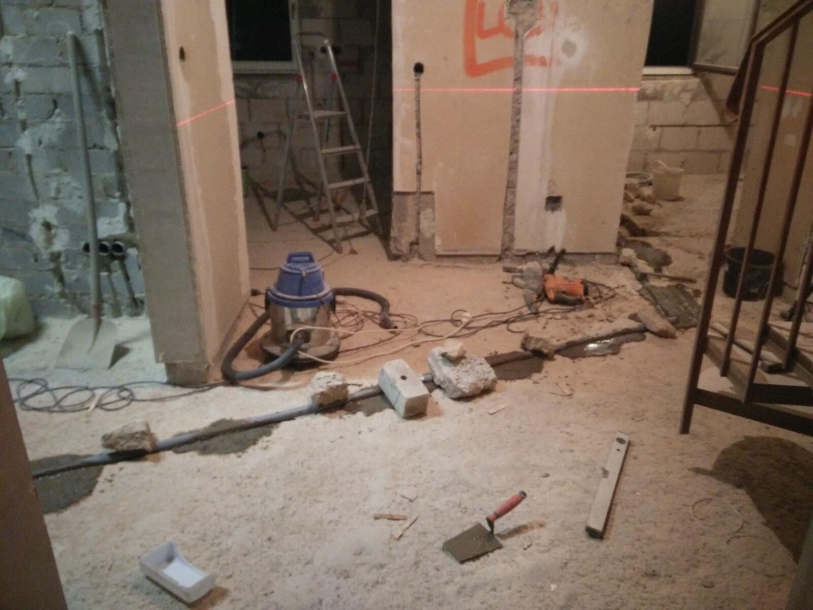 Baustelle im Innenbereich mit Baumaterialien, Staub, Kabeln und Werkzeugen während Umbau