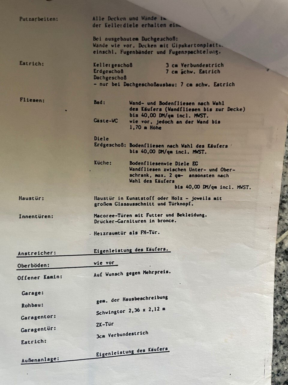 Ein zerknittertes DIN-A4-Blatt mit Bau- und Renovierungsliste: Putzarbeiten, Estrich, Fliesen, Türen.