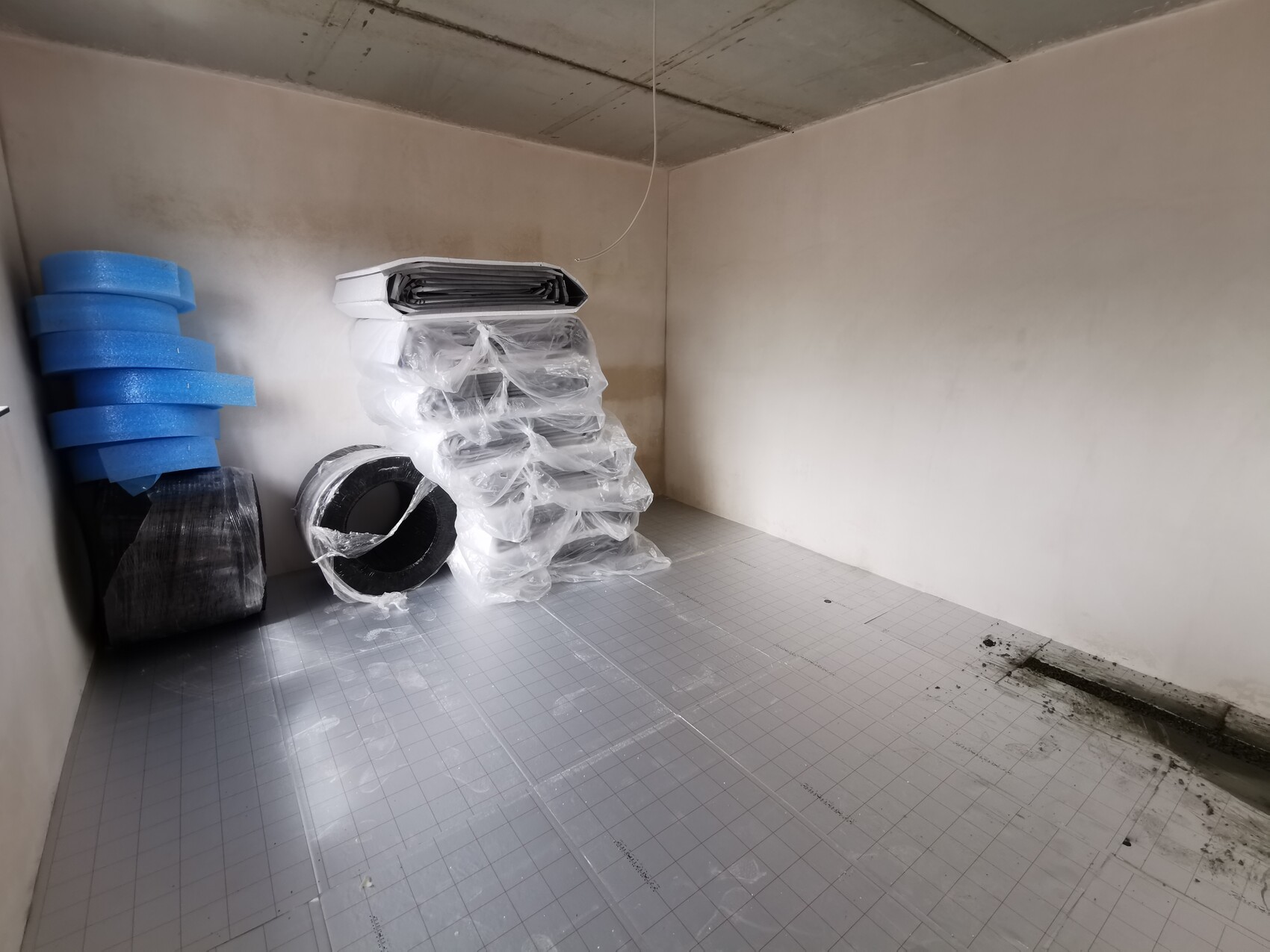 Leerraum mit verpacktem Dämmmaterial und Dämmrollen für Innenausbau