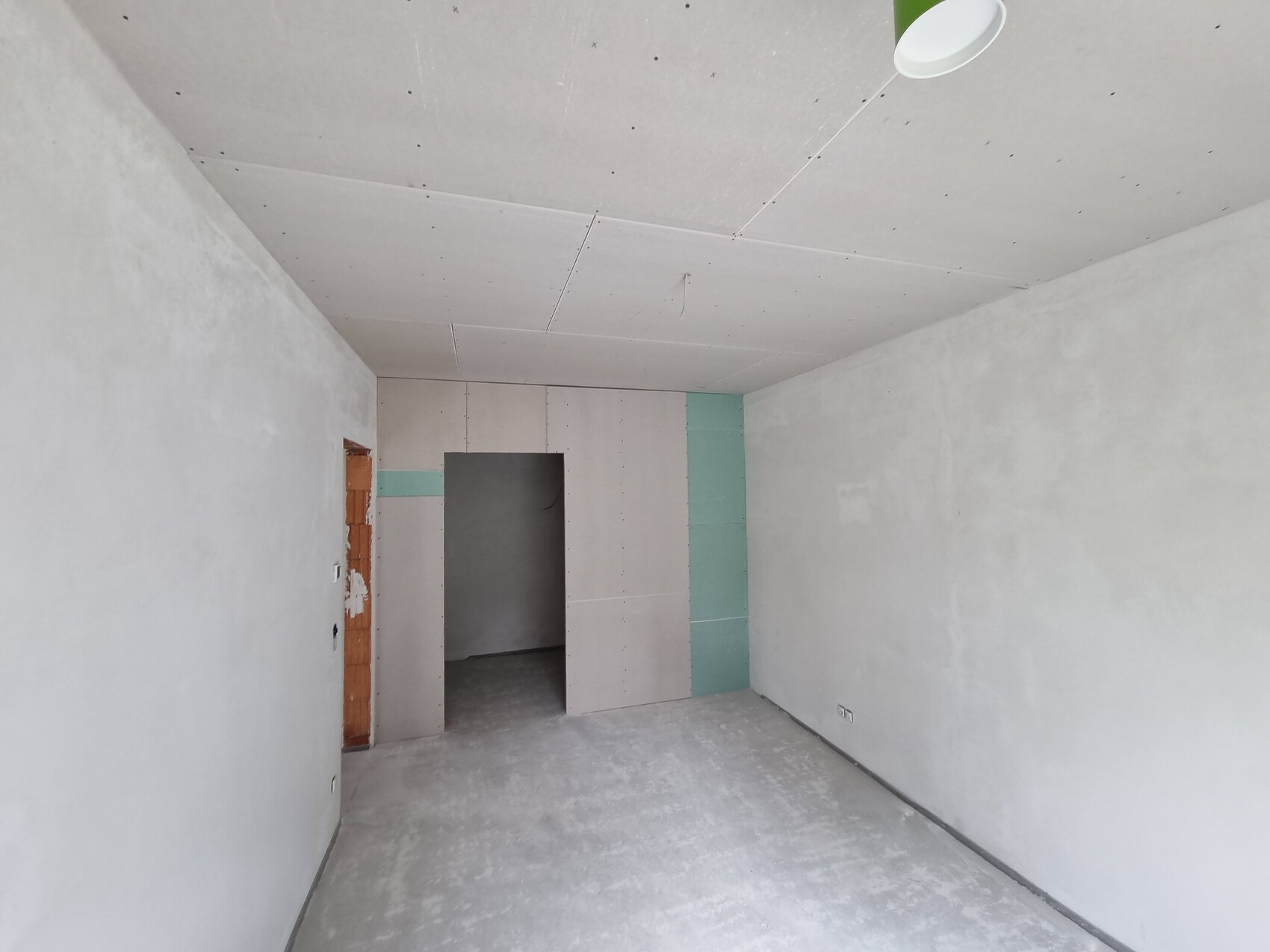 Raum unter Baustelle mit rohen Gipskarton-Wänden, Decke und offener Tür zum Nebenzimmer