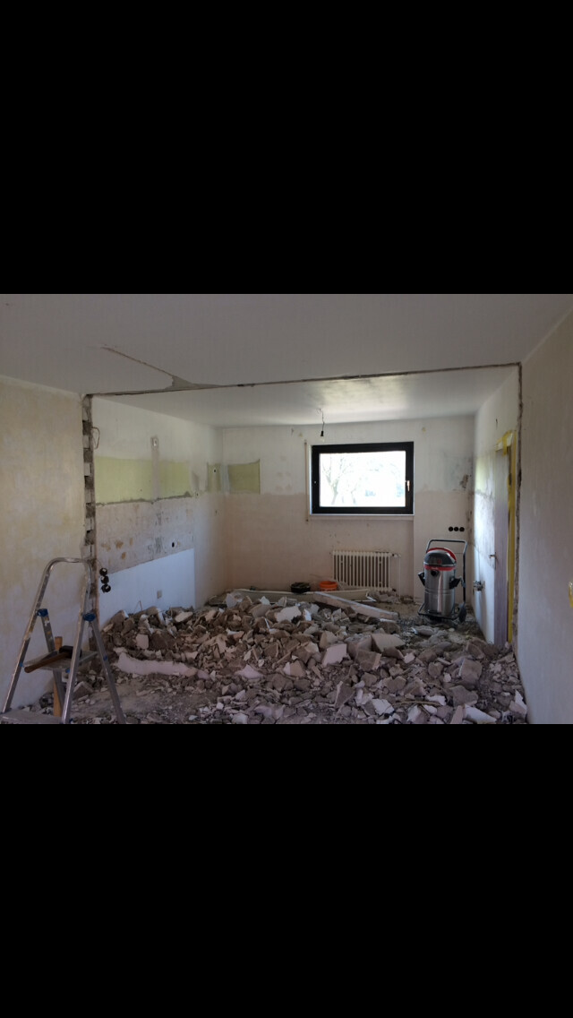 Wohnraum im Umbau mit Trümmern, Leiter, Fenster und Heizkörper