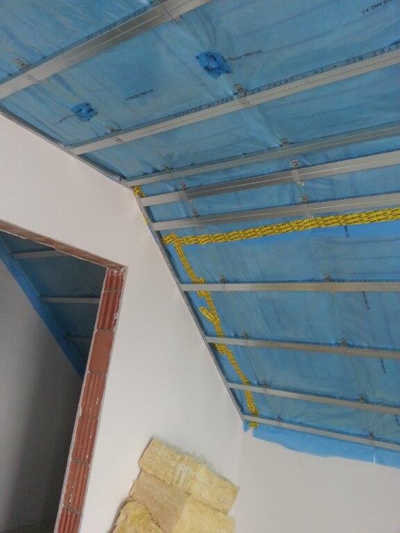 Innenausbau-Baustelle: Decke mit blauem Abdeckmaterial und Metallträgern