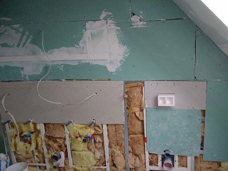 Innenausbau: Wand mit Dämmung, Gipskartonplatten und sichtbaren Kabeln