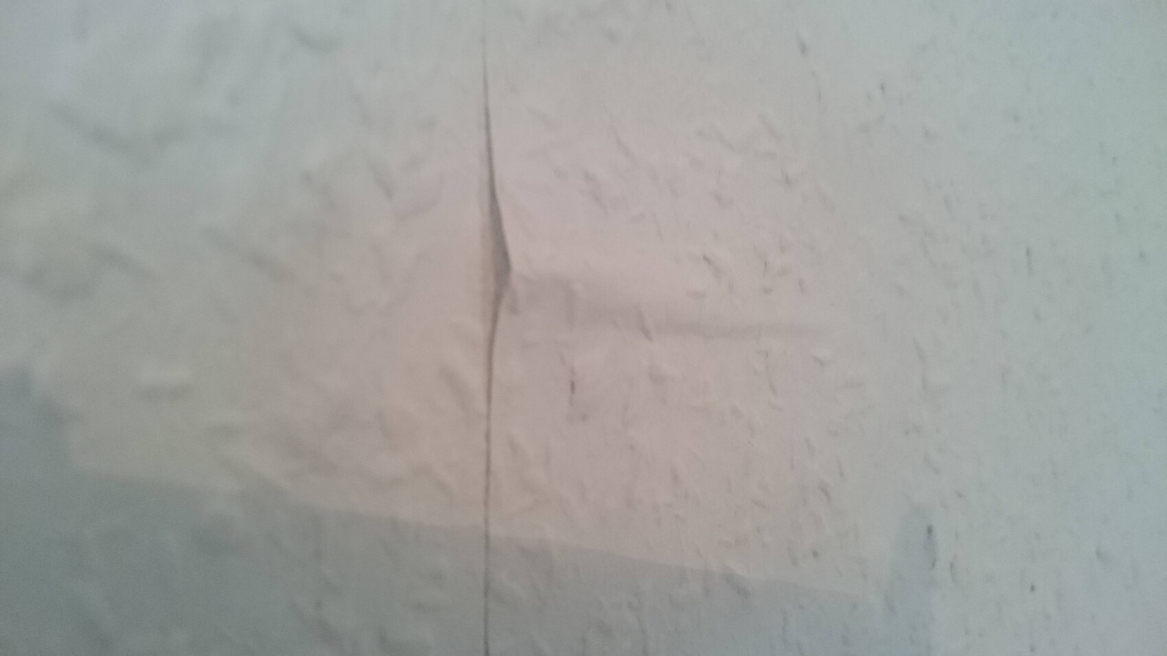 Nahaufnahme einer weißen Wand mit Struktur und Fugennaht