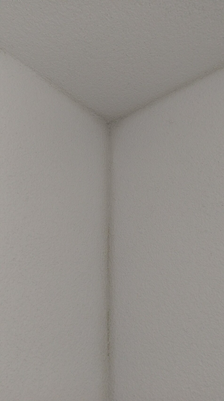 Nahaufnahme einer weißen texturierten Innenwand Ecke im Innenraum