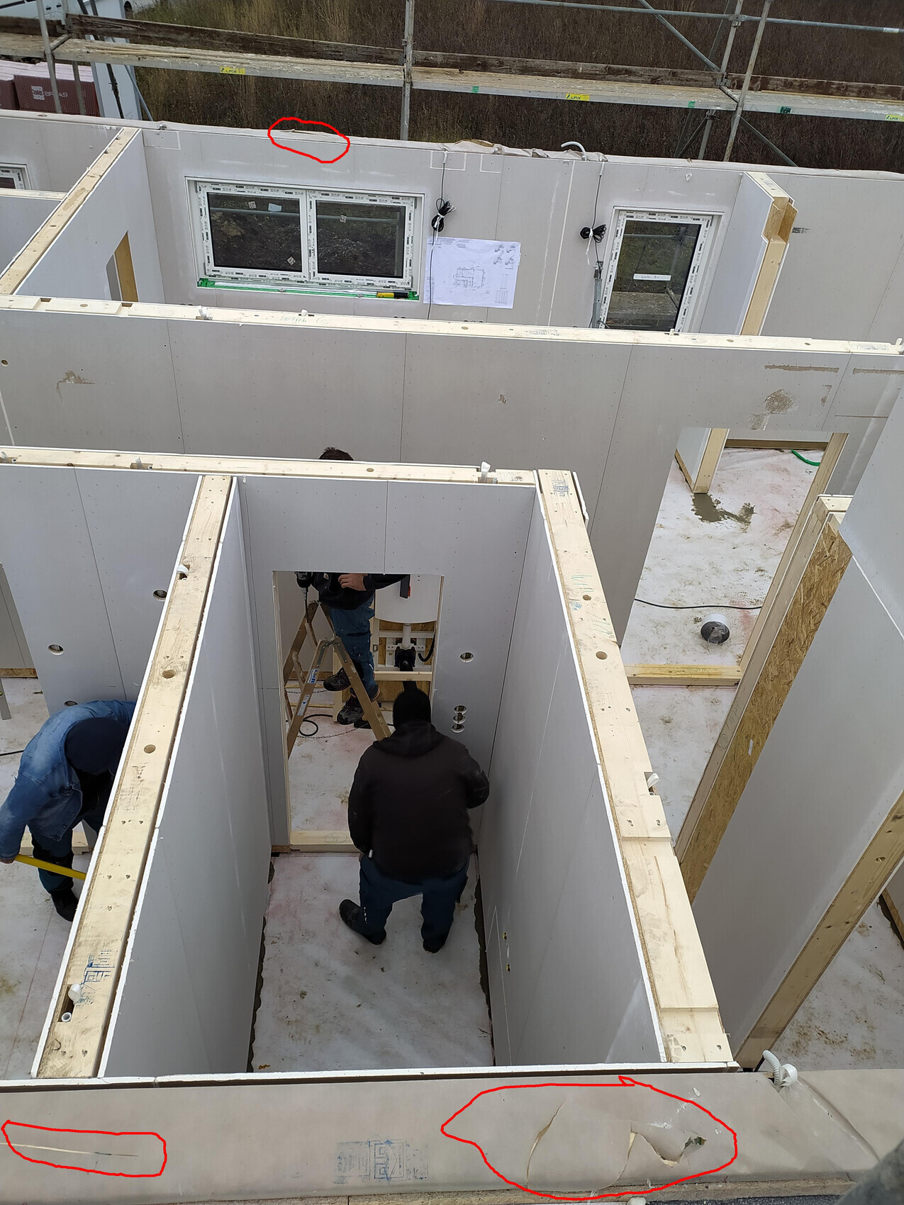 Innenausbau-Baustelle: Gipskartonplatten an Innenwänden werden montiert, Arbeiter arbeiten