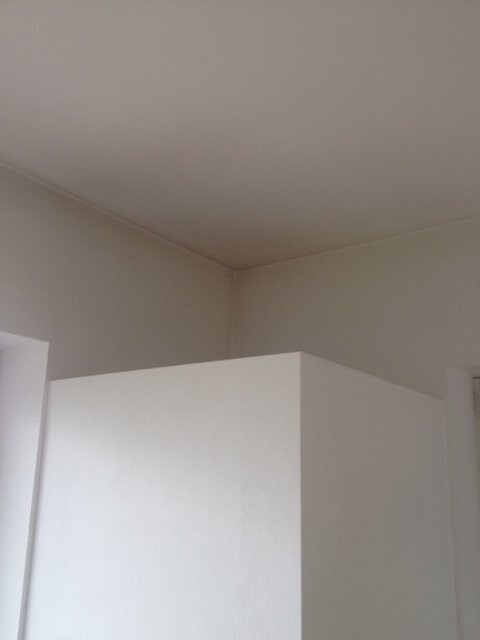 Weiße Innenraumecke mit glatten Wänden und Decke.