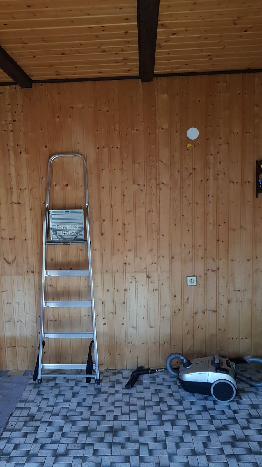 Holzverkleidete Wand, Leiter und Staubsauger in einer Renovierungswerkstatt