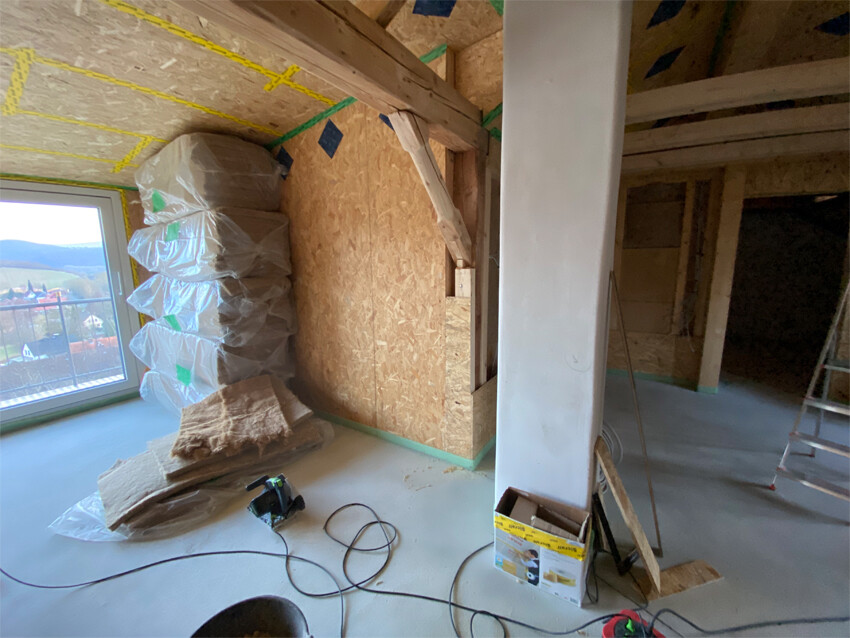 Innenausbaubaustelle mit OSB-Wänden, Dämmung und Bauwerkzeugen