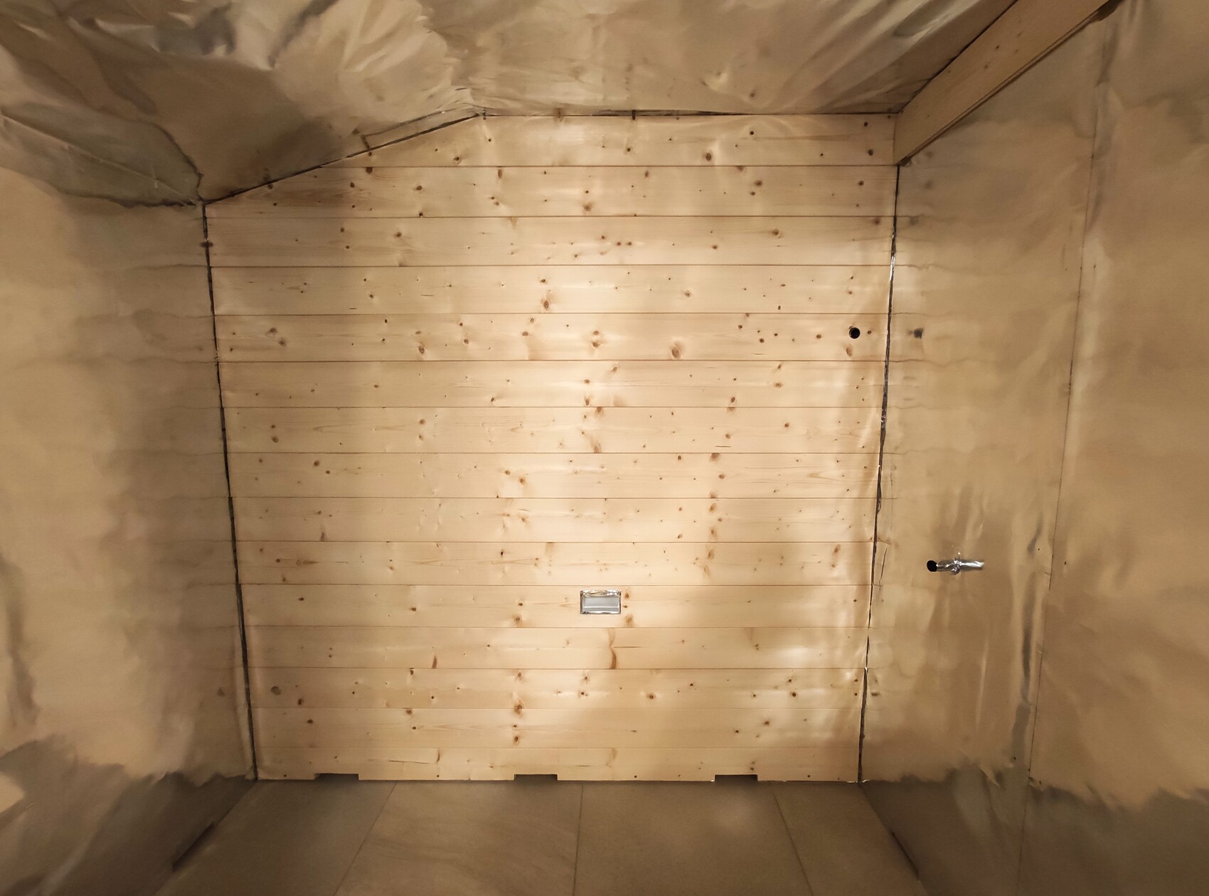 Helle Holzpaneele-Wand aus horizontalen Planken in einem isolierten Innenraum.