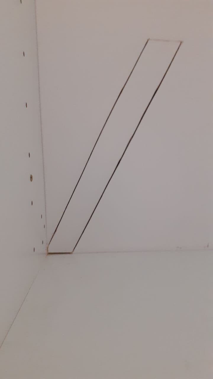 Weiße Schrankinnenwand mit diagonaler, schmaler Leiste von unten links nach oben rechts.