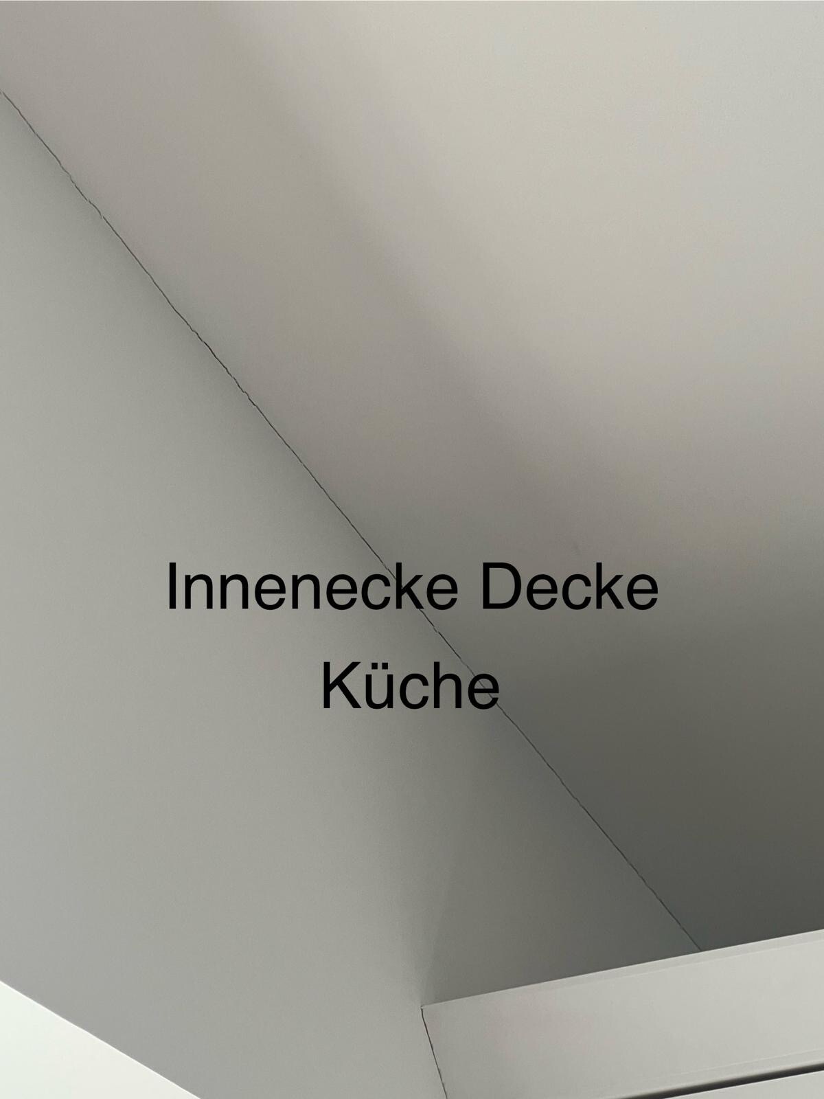 Innenraum-Deckenwinkel in der Küche, graue Deckenfläche und Eckverbindung sichtbar