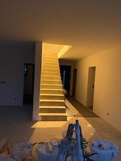 Unterbau eines Innenraums mit hellem Treppenaufgang und Baugeräten