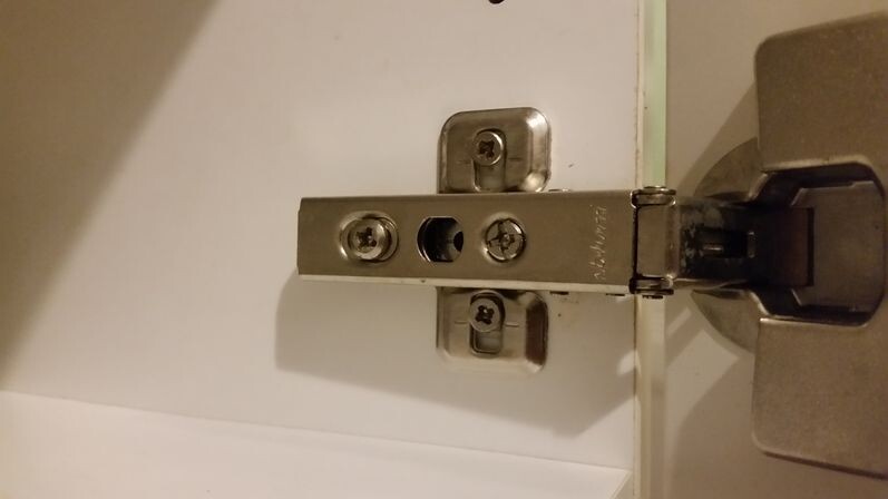 Nahaufnahme eines Türscharniers mit Schrauben und Bolzen