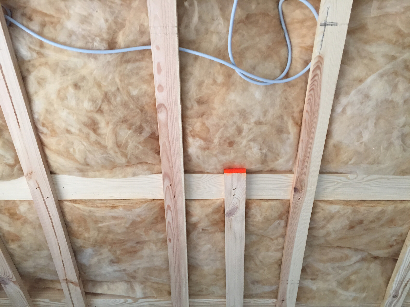 Innenwand mit Holzständerwerk, Dämmung und sichtbaren Kabeln