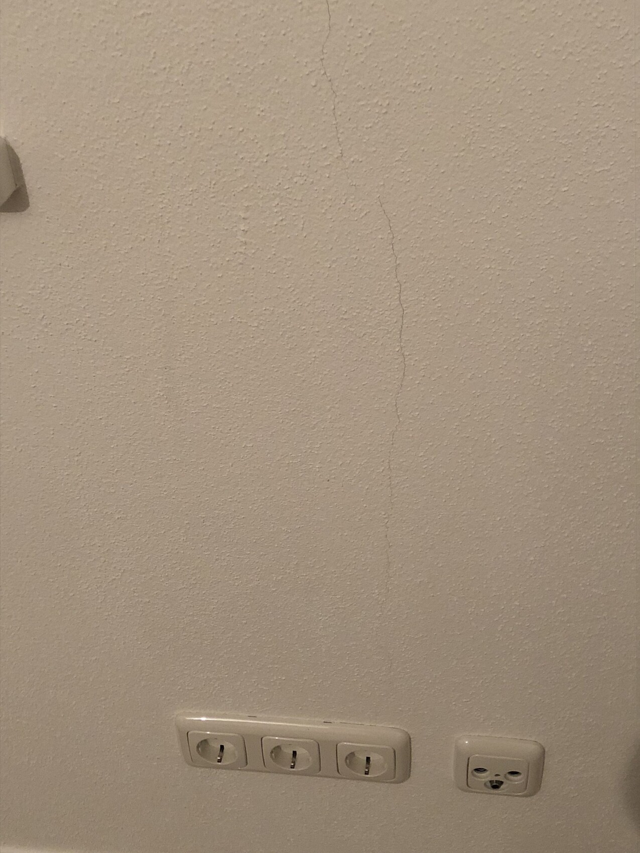 Innenwand mit Riss und Steckdosen im unteren Bereich
