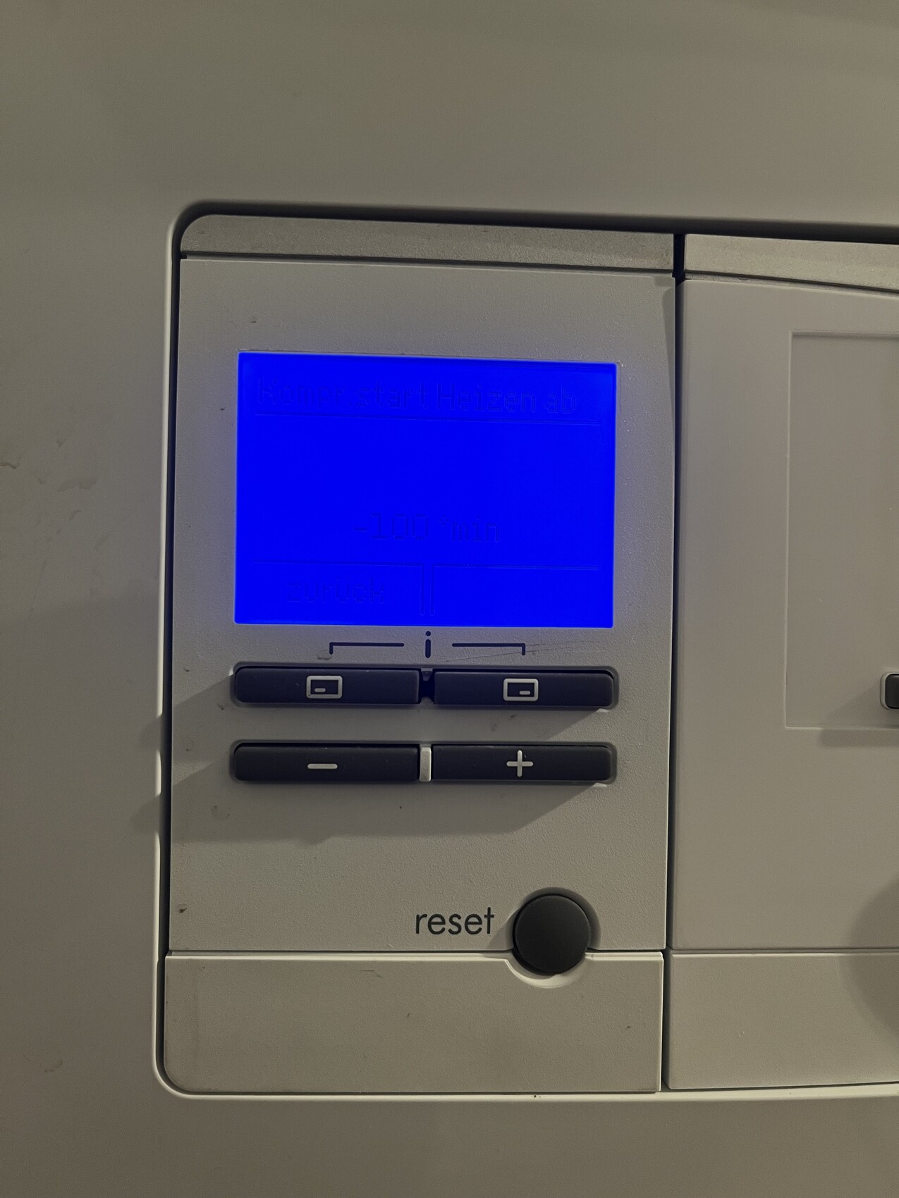 Bedienfeld mit blauem Display, Reset-Taste, +/--Knöpfen und zwei Funktionstasten.