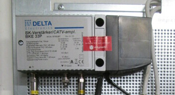 Kabel-TV-Verstärker im Technikschrank an Metallrückwand montiert