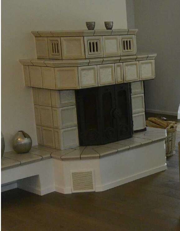 Großer Kamin mit beigefarbener Steinverkleidung und Glastüren im Wohnzimmer.