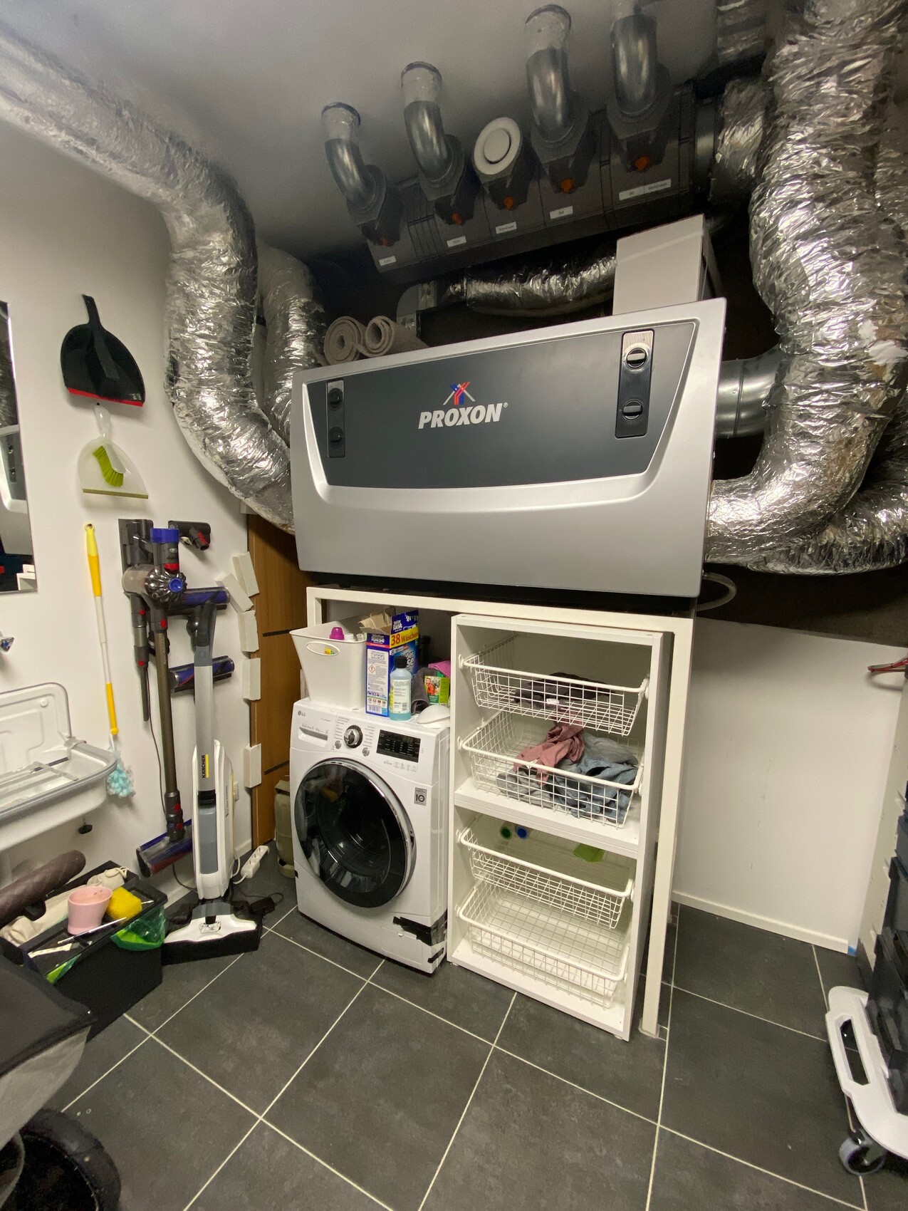 Keller mit Haustechnik: Waschmaschine, Heizungsanlage und Aufbewahrungskörbe