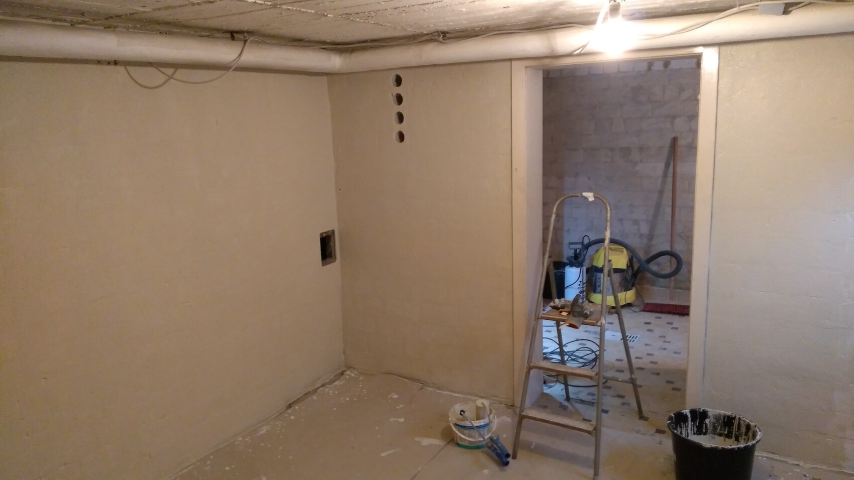 Keller-Baustelle: Leiter, Eimer, Staubsauger, Werkzeugkiste, Bauarbeiten.