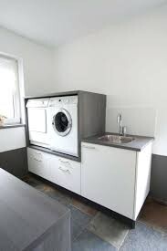 Kleine Küche mit Waschmaschine, Spüle und weißen Schränken