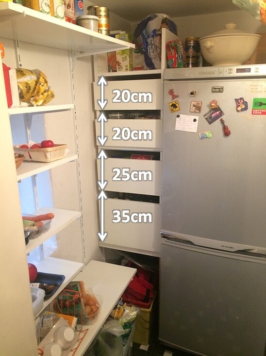 Küchenschrank links mit offenen Regalen und Kühlschrank rechts, Vorräte sichtbar.