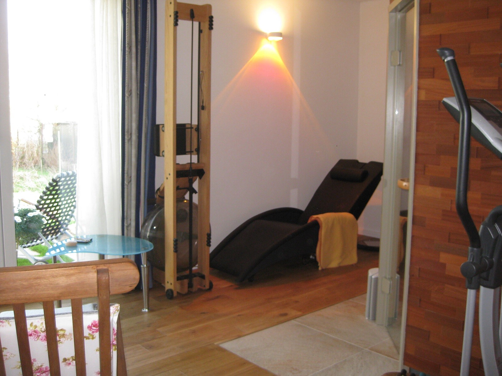 Kleiner Fitnessraum im Wohnzimmer mit Laufband und Trainingsgerät