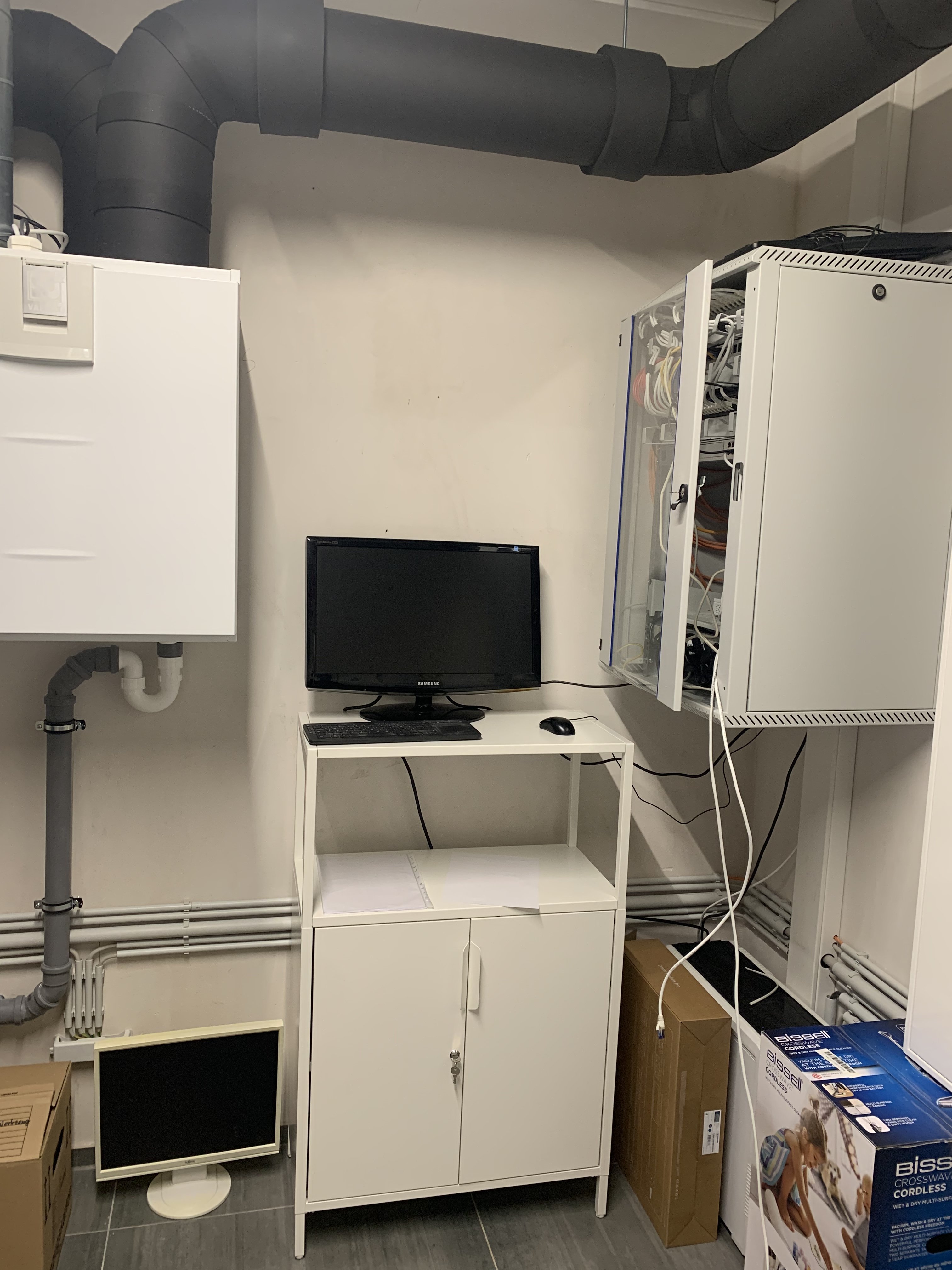 kleiner-technikraum-monitor-serverrack-kabelnetze-lueftungsrohre.jpeg
