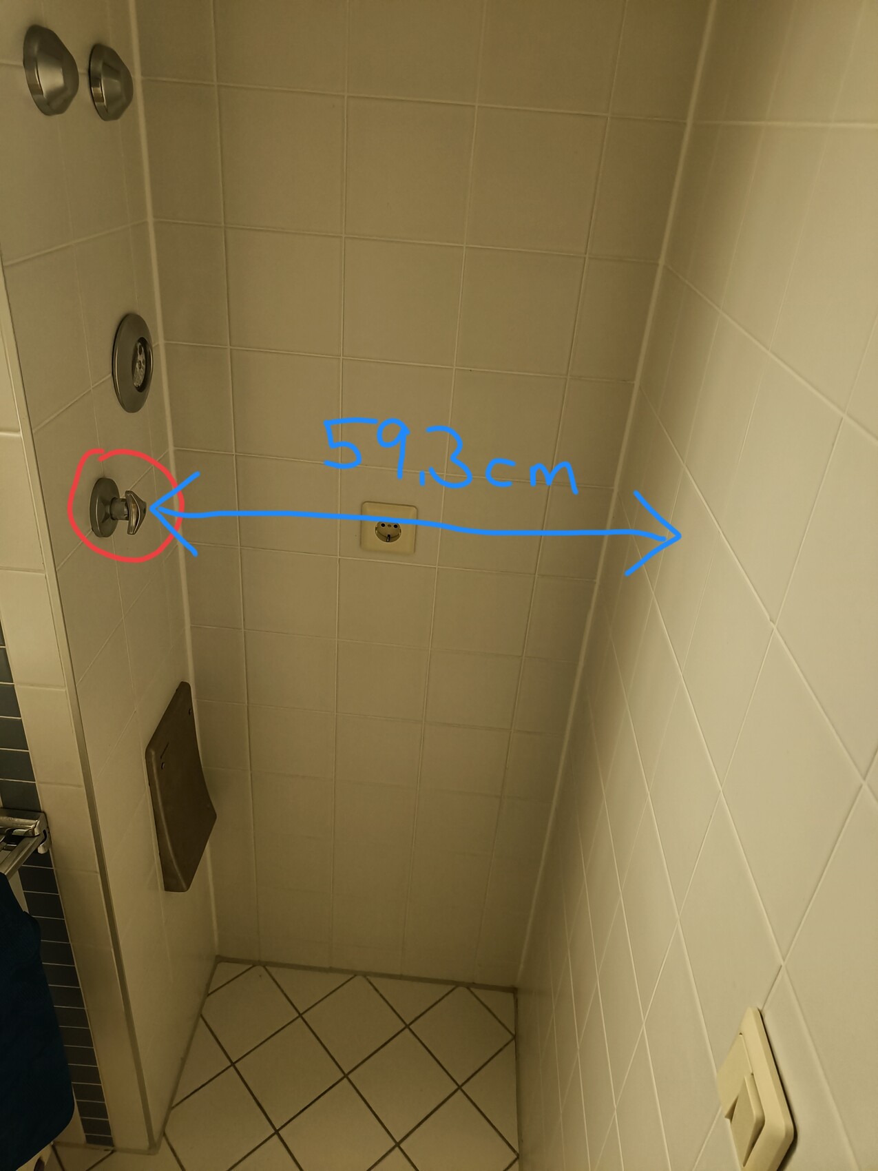 Kleines Badezimmer mit Duschkabine, hellen Fliesen und Armaturen.