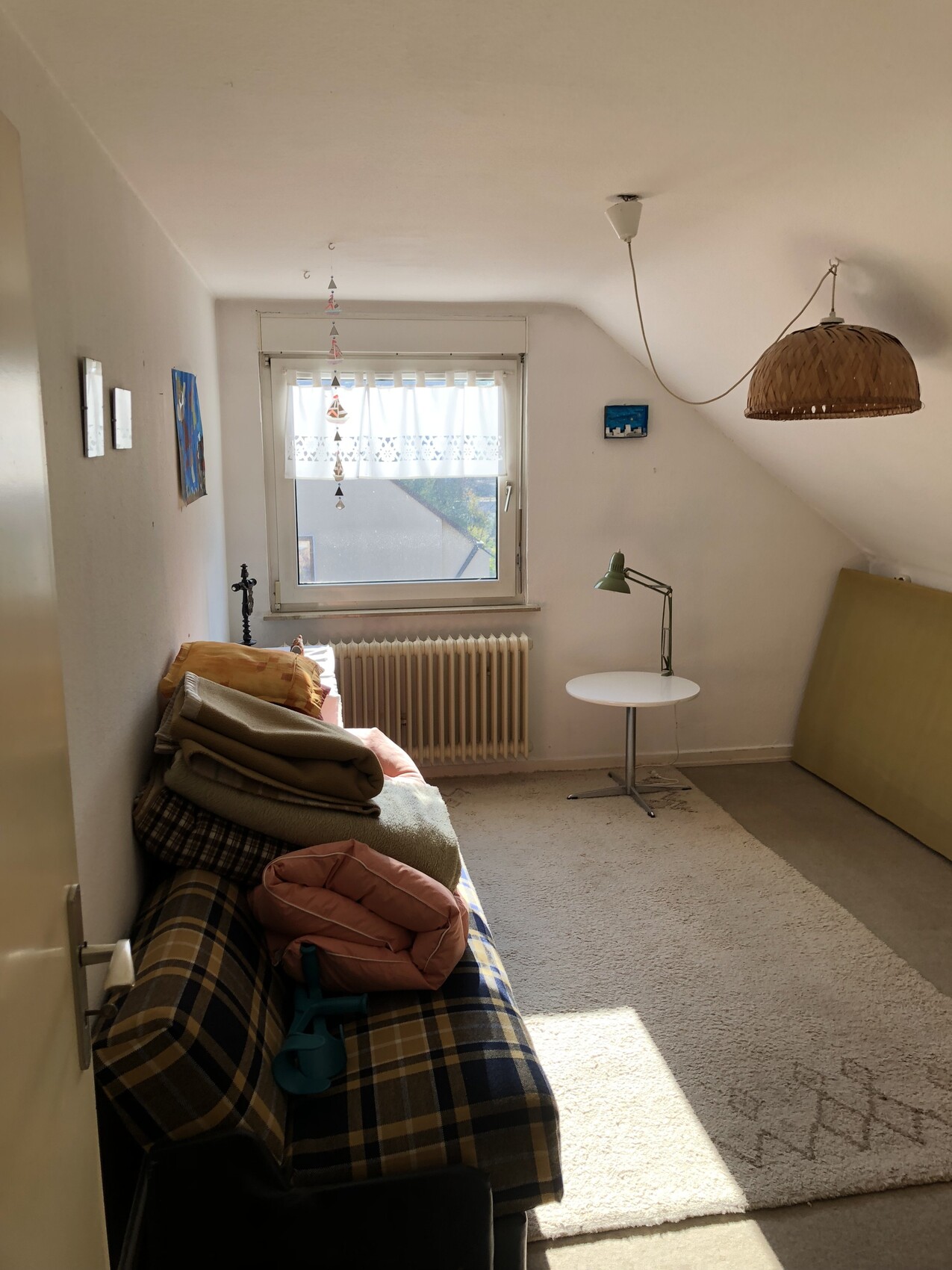 Kleines Dachgeschosszimmer: Sofa mit Deckenstapeln, Fenster, rattan Pendelleuchte, Teppich