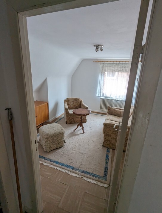 kleines-vintage-wohnzimmer-mit-sesseln-und-rundem-tisch-und-teppich.jpg
