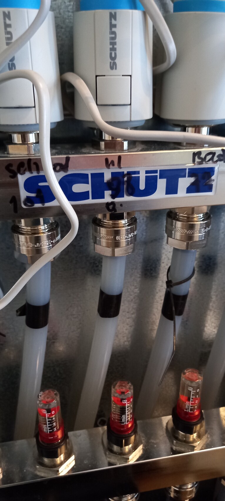 Nahaufnahme eines Pneumatik-Blocks mit drei Schlauchverbindungen und Messanzeigen.