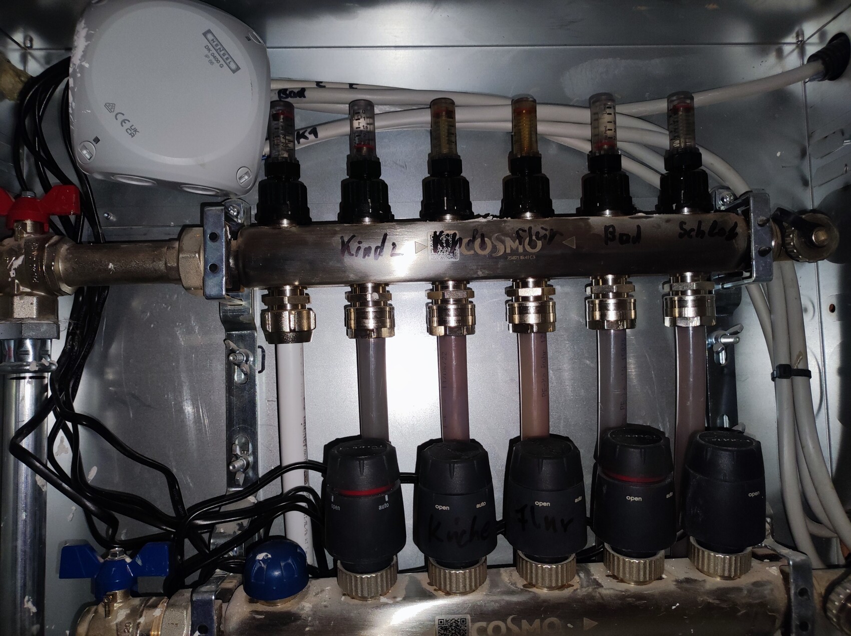 Rohrverteilung mit Absperrhähnen, Schläuchen und Kabeln in einem Technik-Schrank