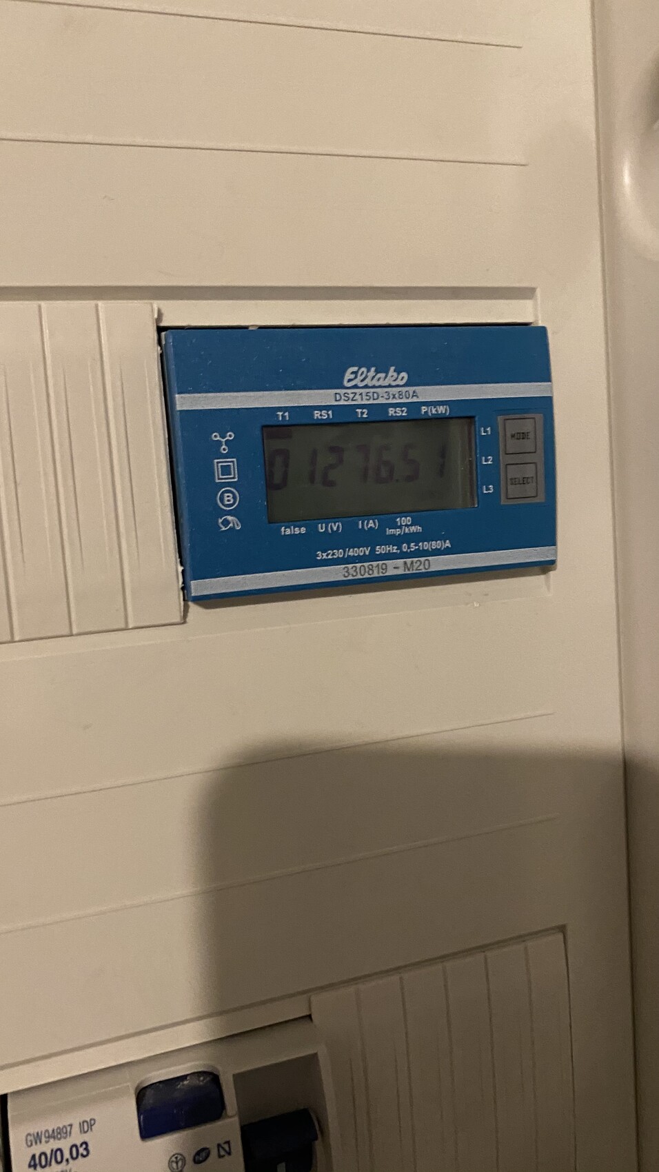 Blauer Eltako-Drehstromzähler DSZ15D-3x80A in einer Wandverkleidung.