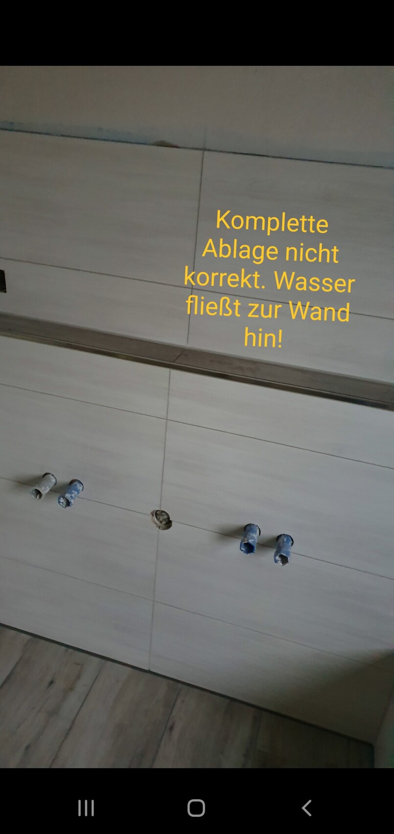 Unvollständige Ablage: offene Wasseranschlüsse, Wasser fließt zur Wand.