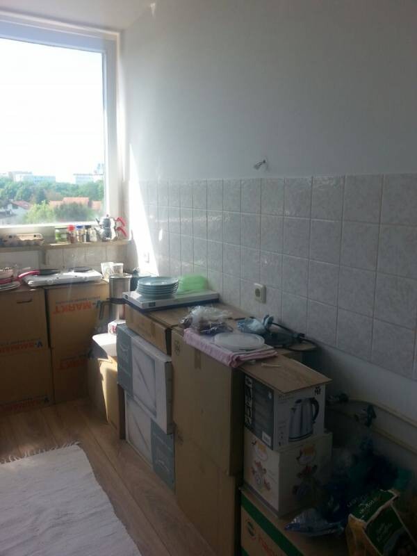 Küche im Umbau mit Kartons, Boxen und Arbeitsfläche am Fenster