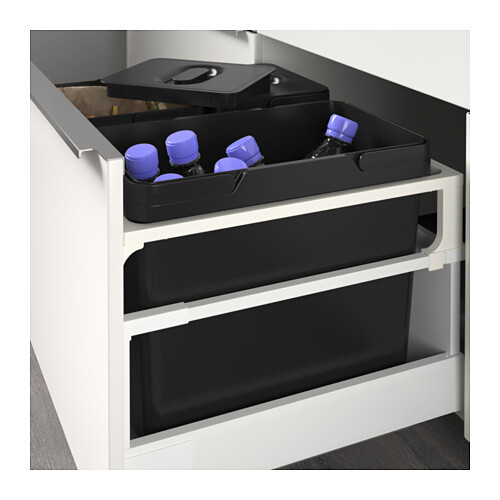 Ausziehbare Küchenschublade mit schwarzem Behälter und Tray mit Wasserflaschen (blaue Kappen).