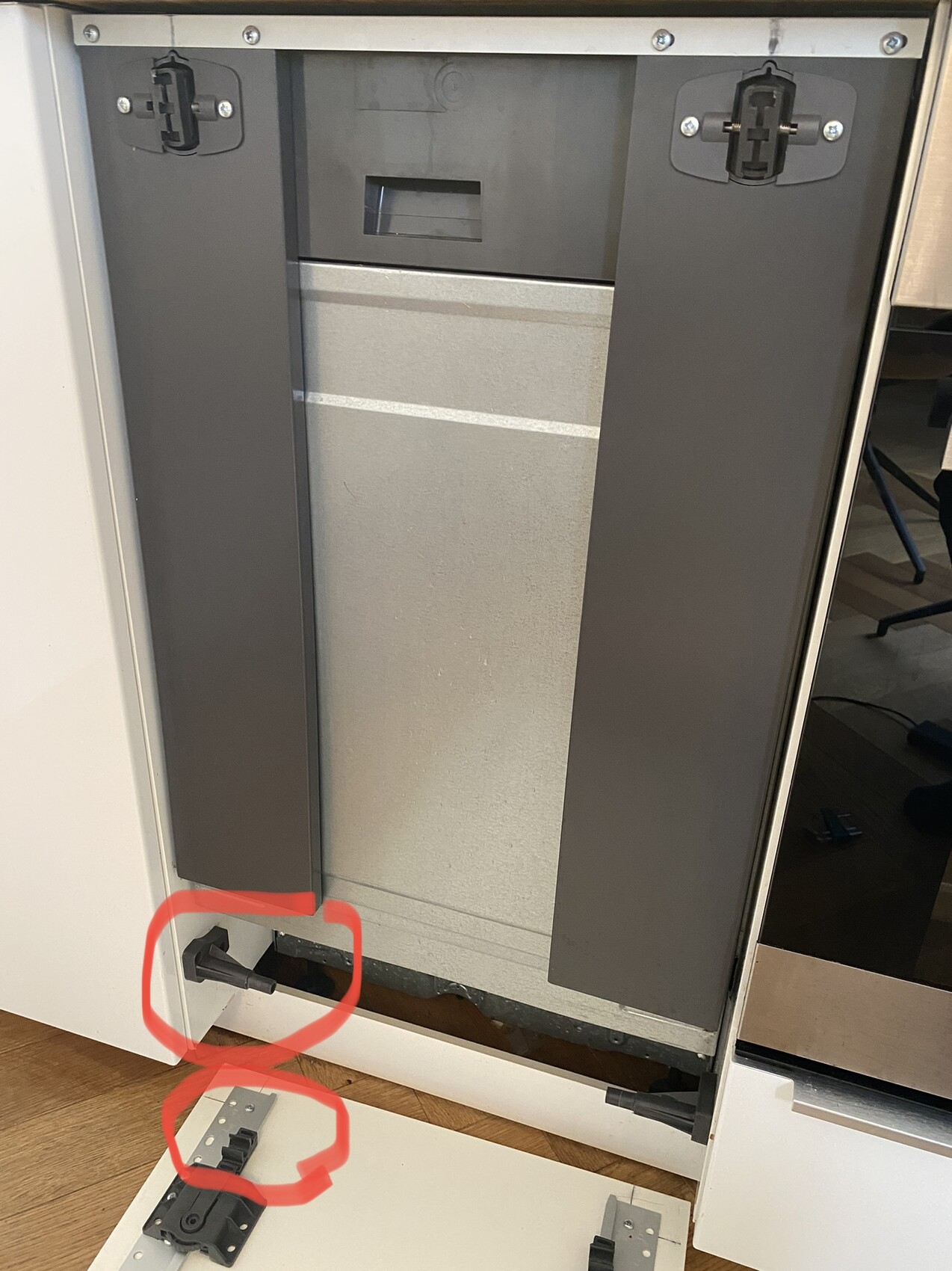 Unterbau-Geschirrspüler mit abmontierter Sockelverkleidung und freiliegenden Verstellfüßen.